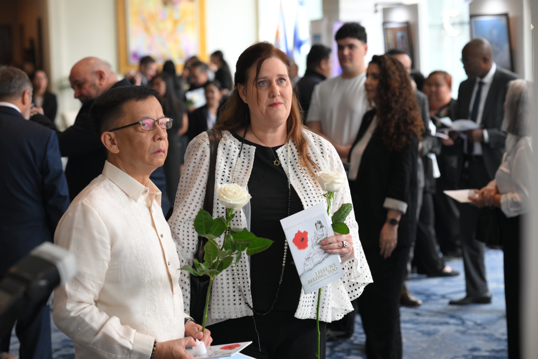 DMW Secretary Hans Leo Cacdac and Ambassador Dana Kursh view a photograph of one of the Filipino victims of the October 7 attacks.