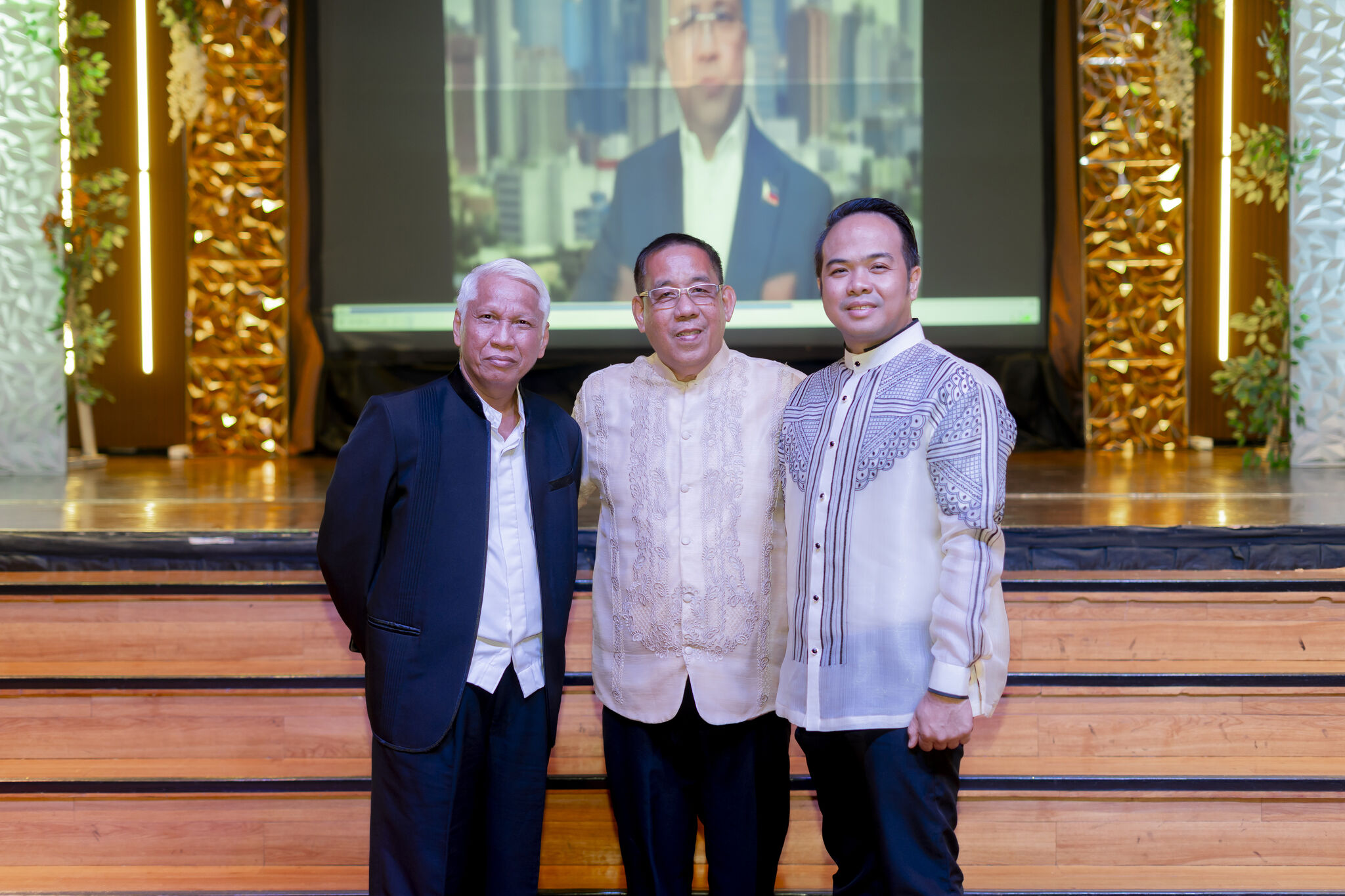 Three participants share a moment beside the Icons of Change stage.