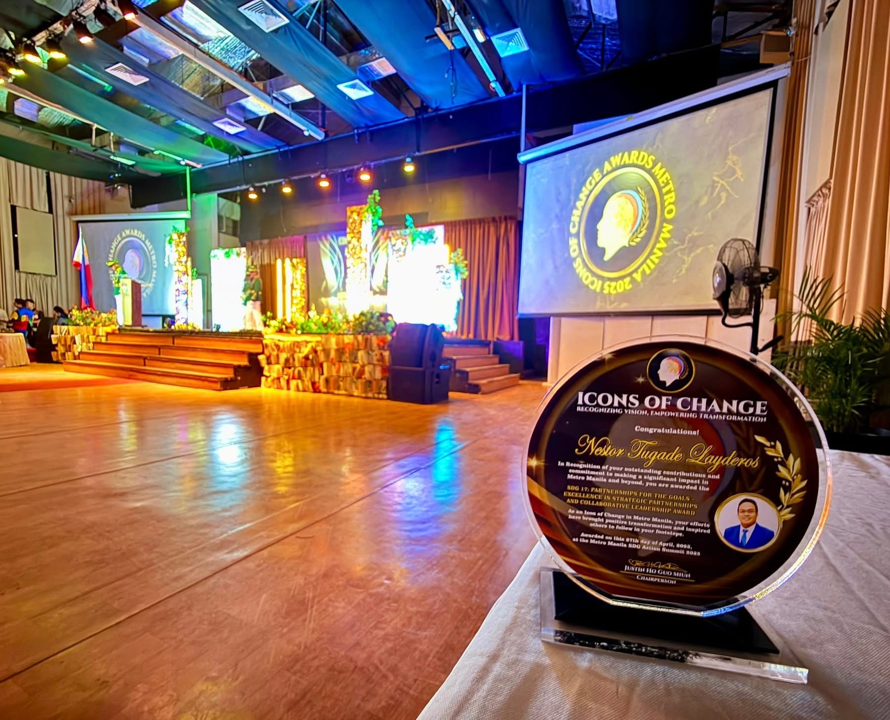 Sir Next’s SDG 17 award plaque in the foreground of the Icons of Change Metro Manila 2025 venue