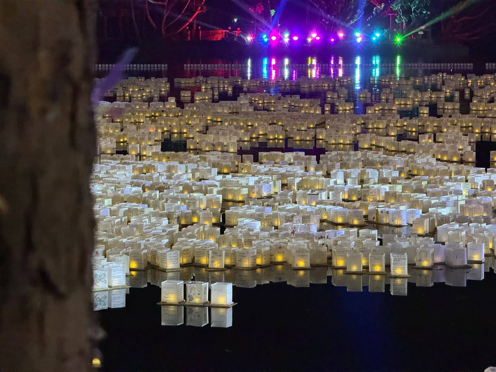Archive photograph of glowing water lanterns beside a festival crowd